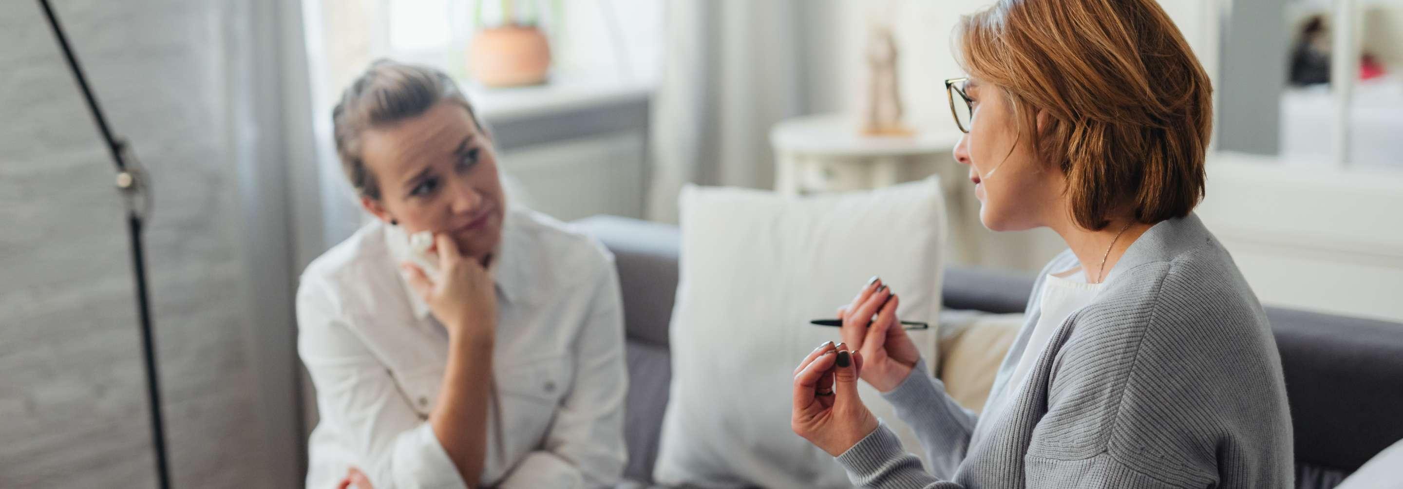 A behavioral case manager counsels a worried client in a private office
