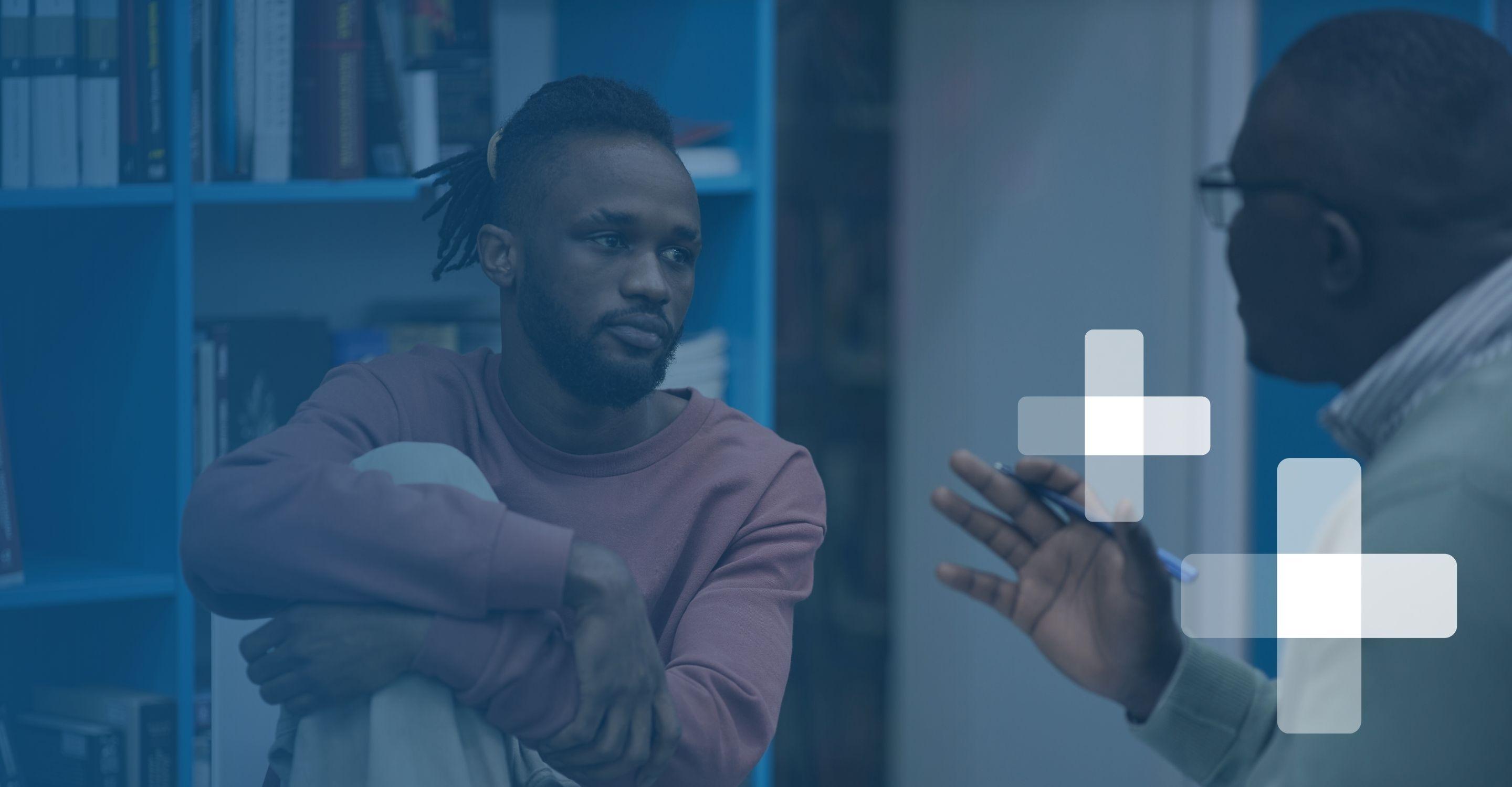 A mental health professional counsels a young black man