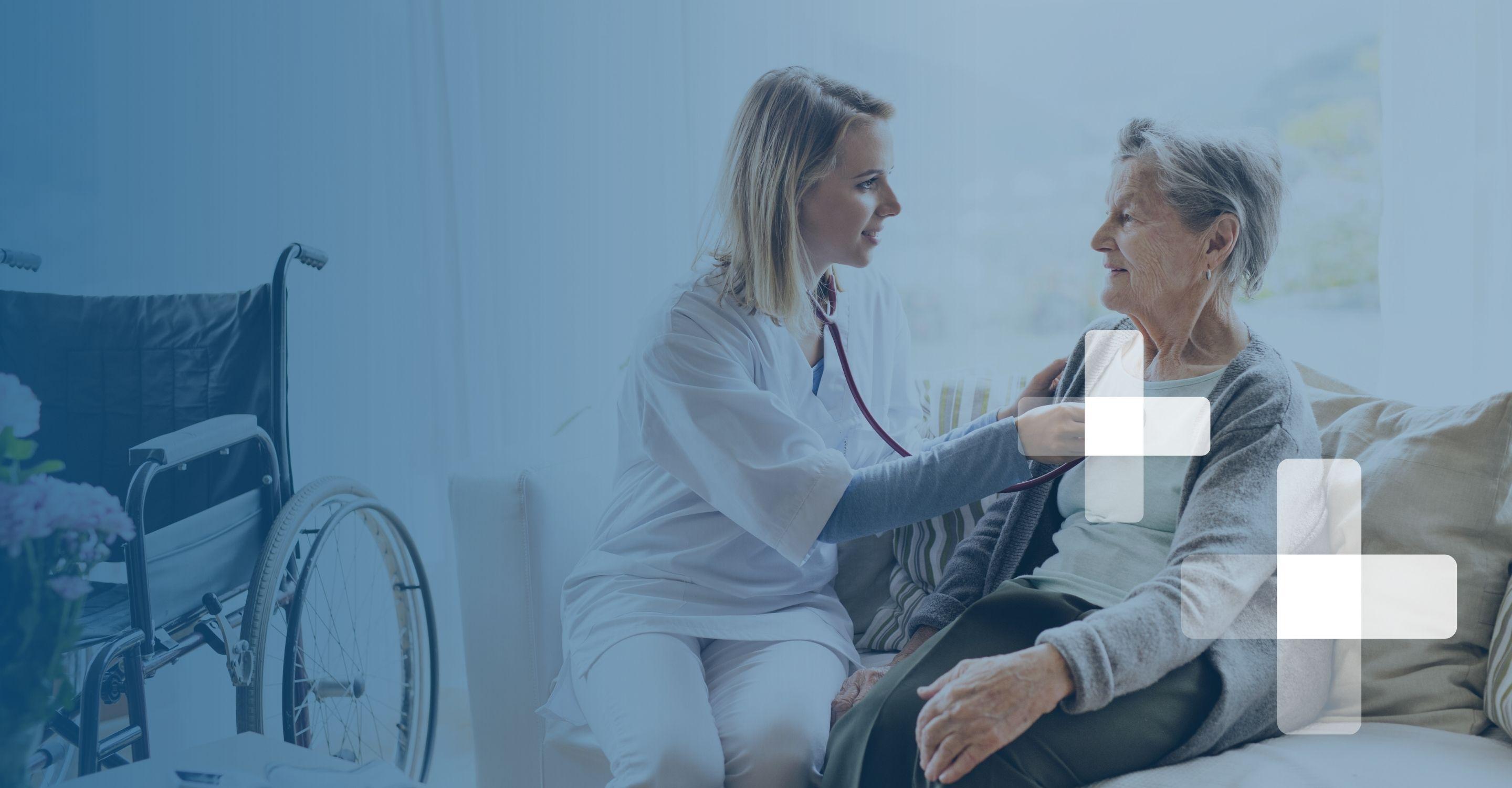 A female home health aid in scrubs uses a stethoscope to listen to the heart rhythms of an elderly woman on her couch