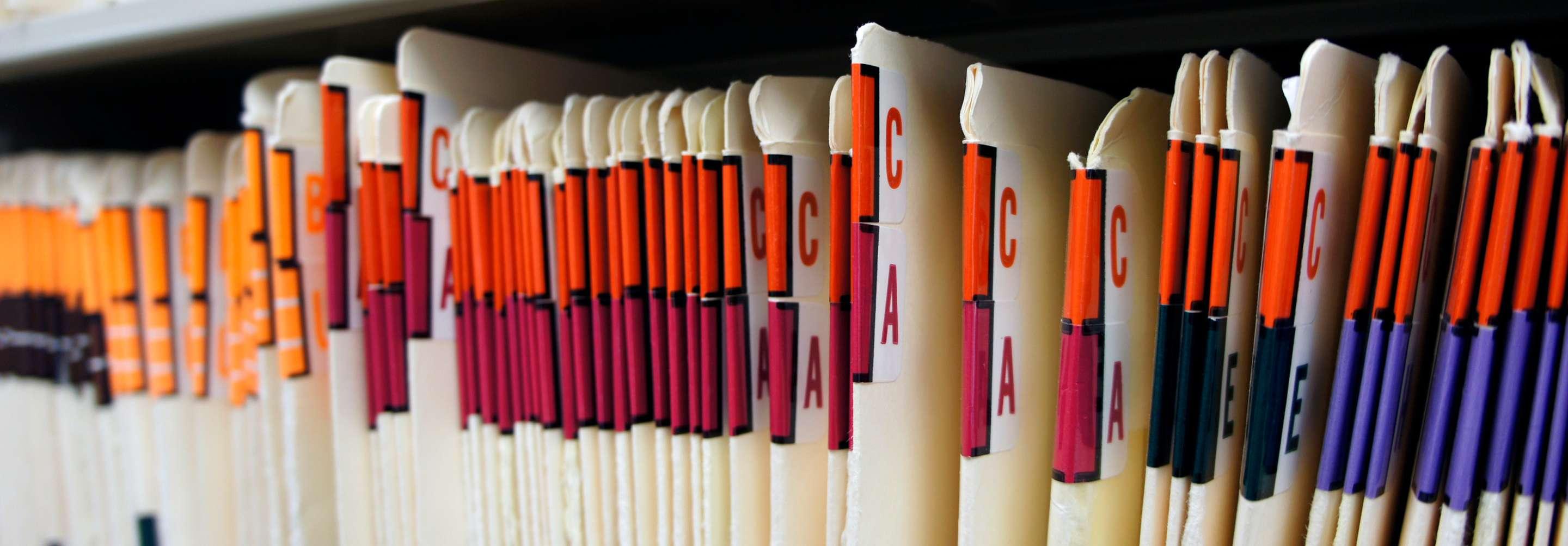 Records clerk color-coded paper files and paperwork