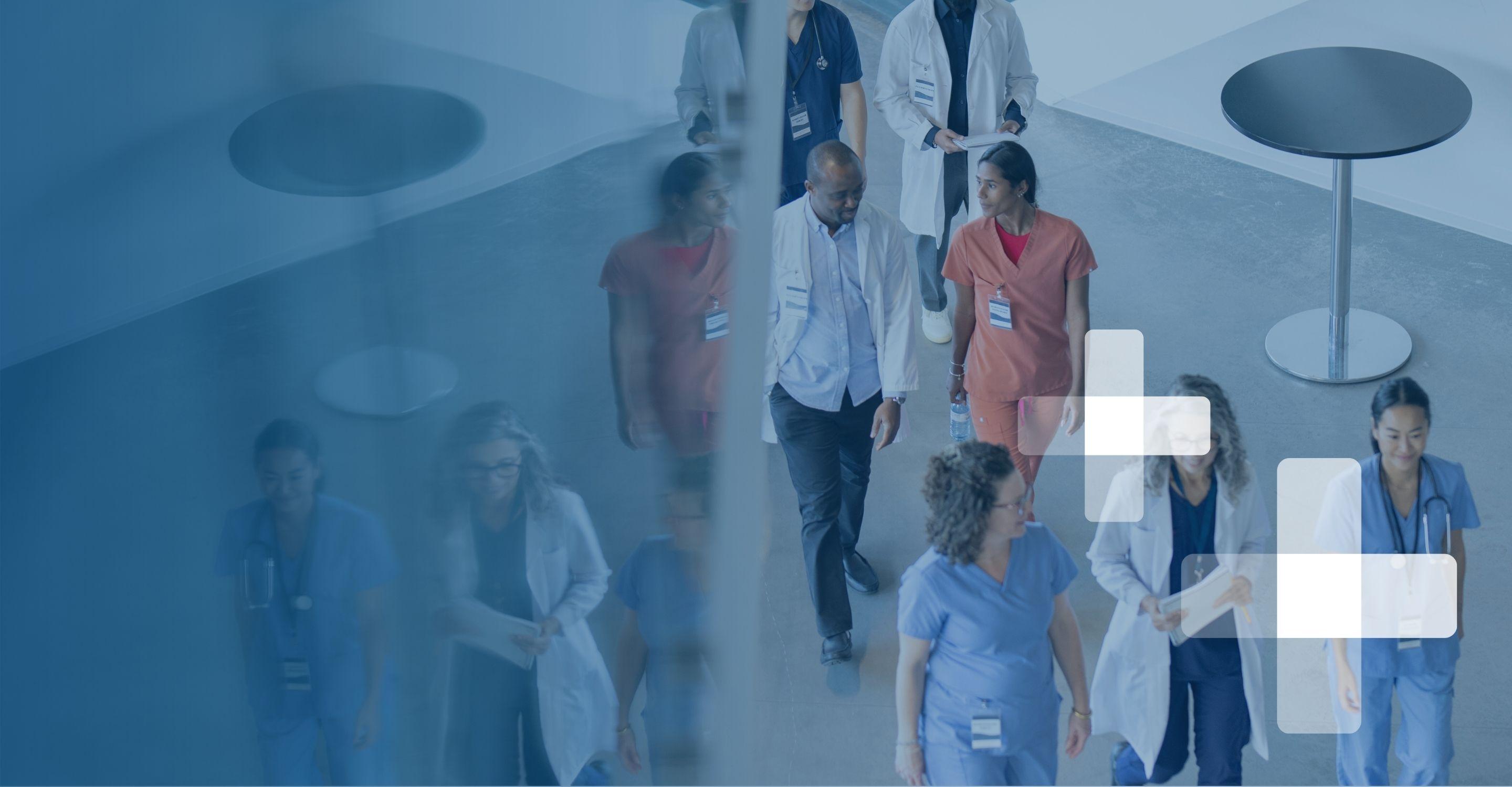 Group of healthcare professionals in scrubs and lab coats standing together.