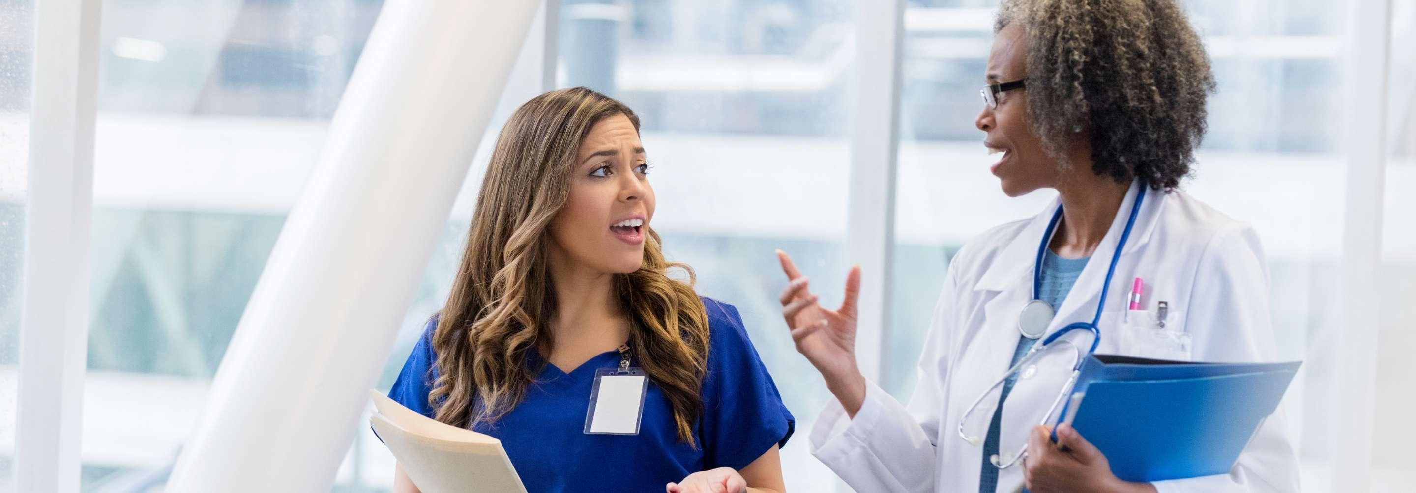 RN Case Manager speaking in the hallway of a facility with a coworker